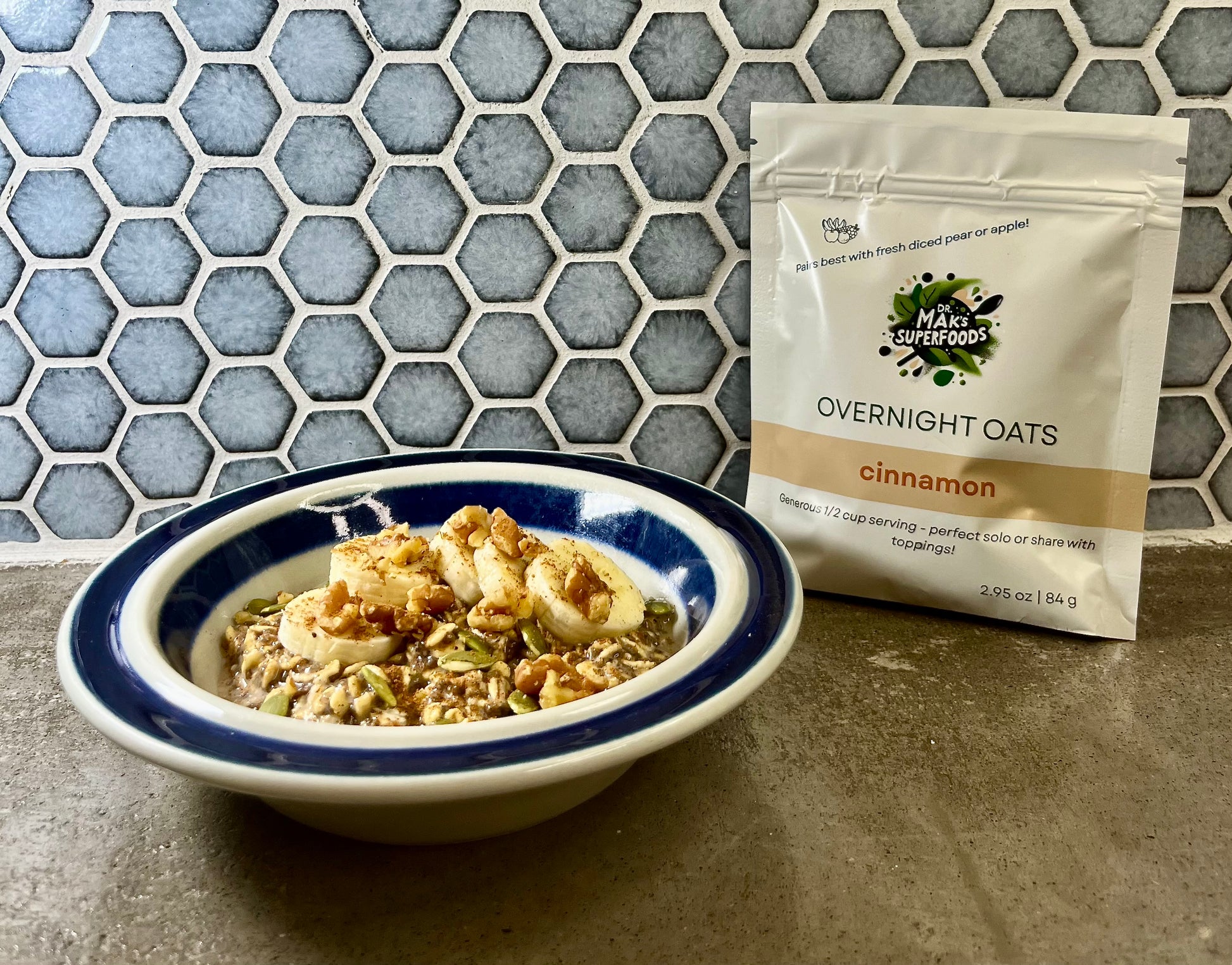 Cinnamon flavor organic overnight oats in a bowl with banana and walnuts by Dr. Mak's Superfoods.