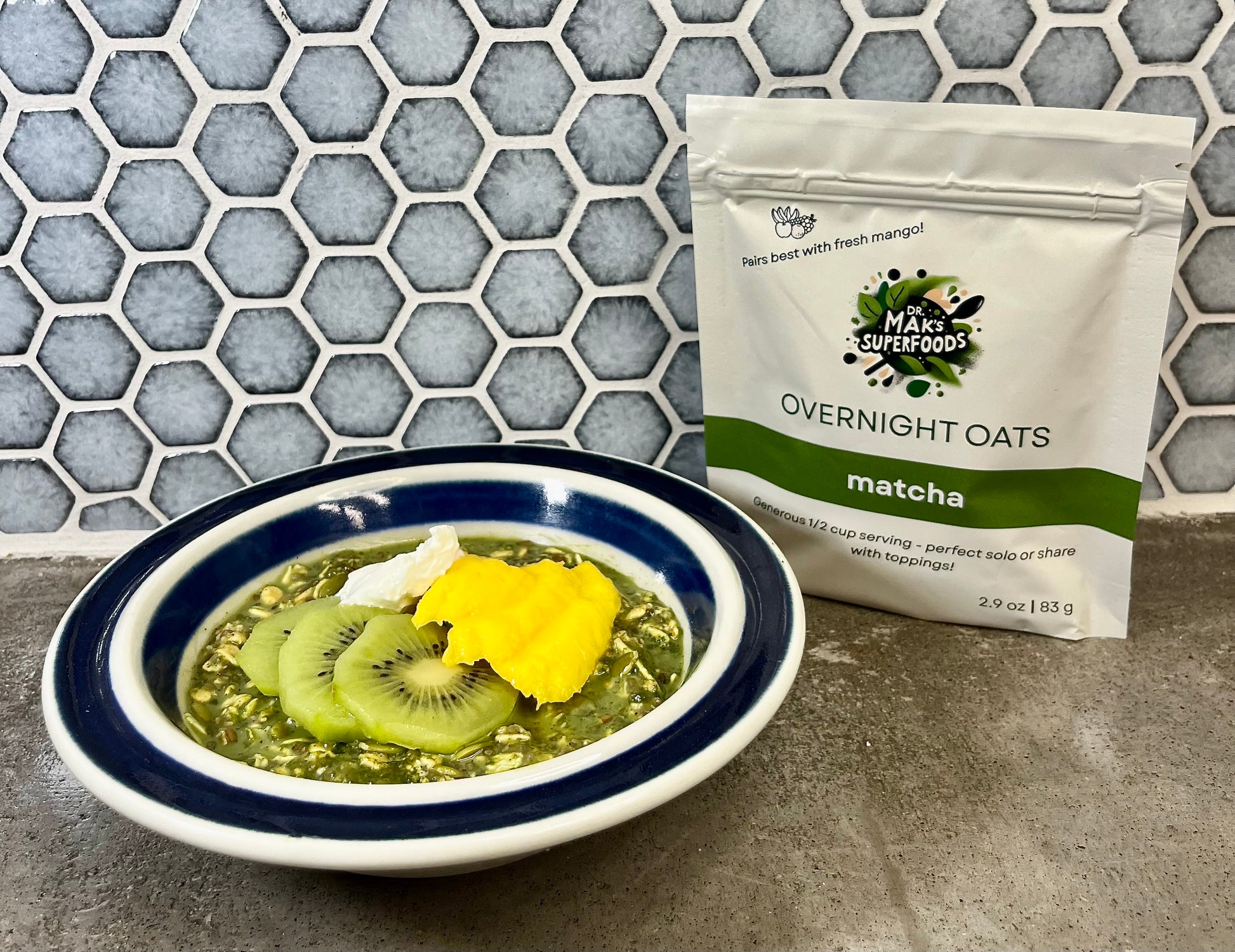 Bowl of matcha overnight oats with a package of Matcha Overnight Oats on a countertop.